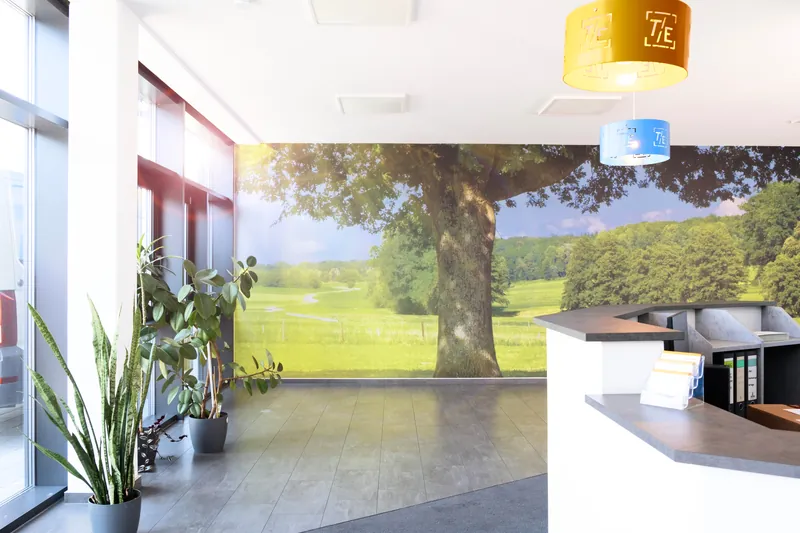 Empfangsbereich mit Wandbild einer Sommerlandschaft