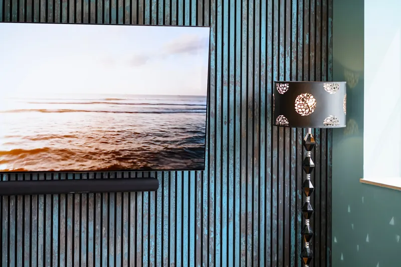 Wandbild vor der Akustikwand mit dunklen Lamellen