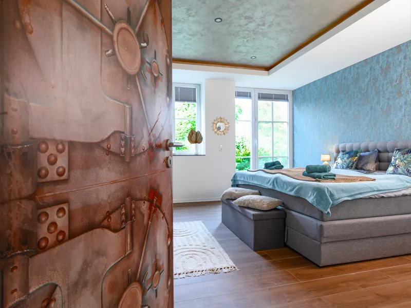 Tür in Rostoptik mit Blick ins gestaltete Schlafzimmer
