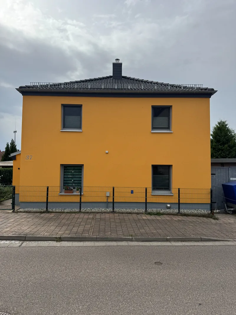 Dasselbe Wohnhaus nach dem Fassadenanstrich in Ocker